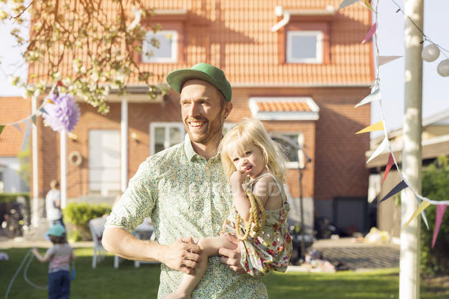Uomo che porta la figlia nel cortile posteriore — Foto stock