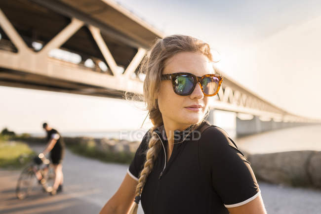 Ciclistas bajo puente en la costa - foto de stock