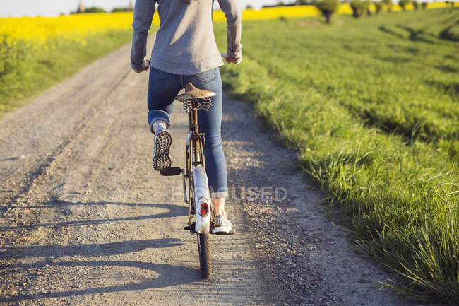 Femme vélo sur la route de campagne — Photo de stock