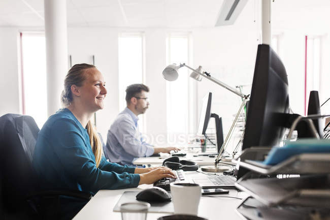 Colleagues working at computers in office interior — Stock Photo