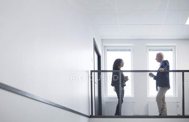 Mujer y hombre hablando en el pasillo - foto de stock