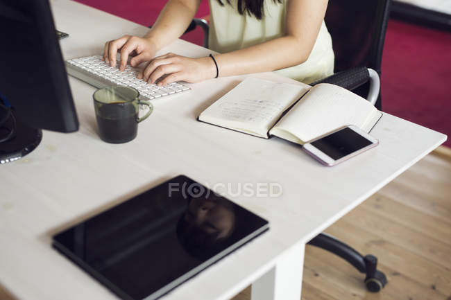 Femme utilisant l'ordinateur dans le bureau — Photo de stock