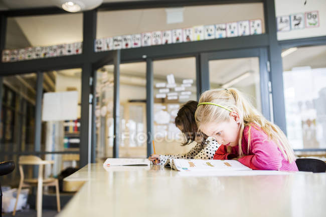 Mädchen lernen im Klassenzimmer mit Lehrbüchern — Stockfoto