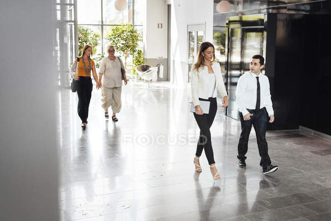 Colleagues walking through lobby — Stock Photo