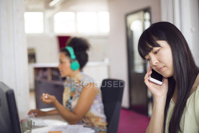 Woman talking on phone in office — Stock Photo