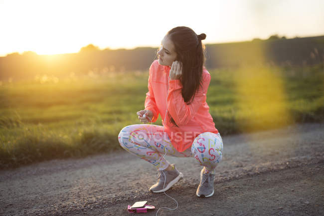 Woman crouching on dirty road — Stock Photo