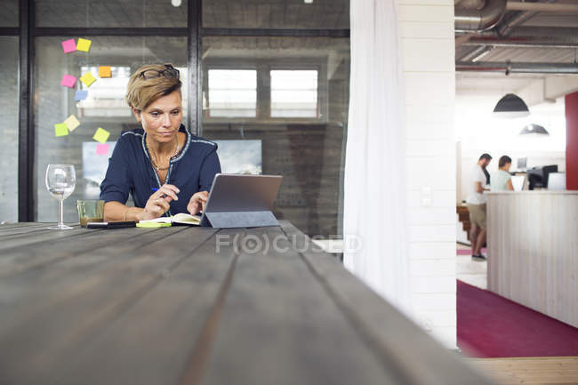 Woman using laptop in office — Stock Photo