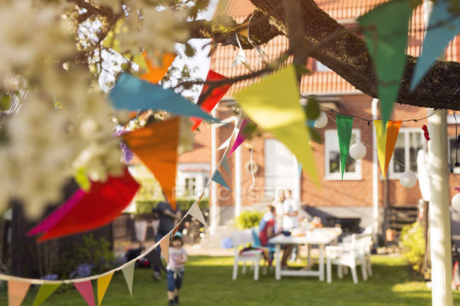 Colorful bunting in garden with people in the background — Stock Photo