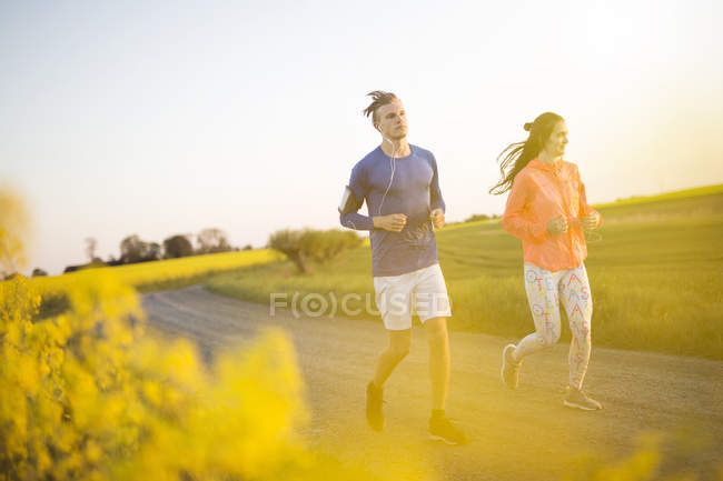 Couple running on countryside road — Stock Photo