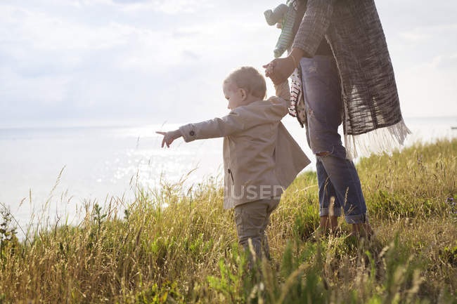 Mother walking with son towards sea — Stock Photo