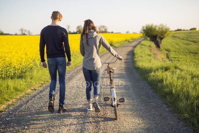Casal caminhando na estrada rural — Fotografia de Stock