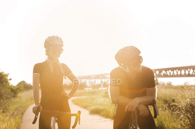 Ciclistas em pé na estrada rural — Fotografia de Stock