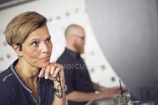 Woman holding eyeglasses in hand — Stock Photo