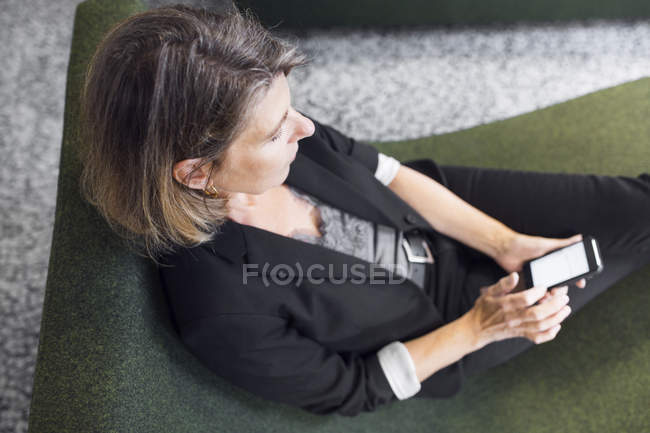 Жінка сидить у затишному крісло — стокове фото