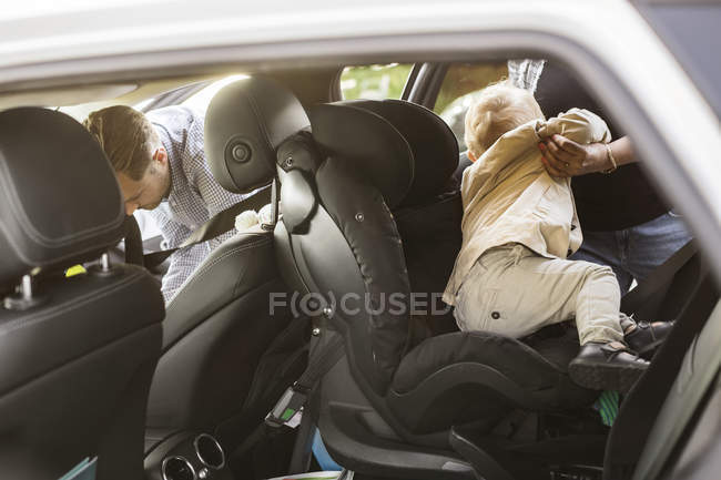 Мать вытаскивает сына из машины — стоковое фото