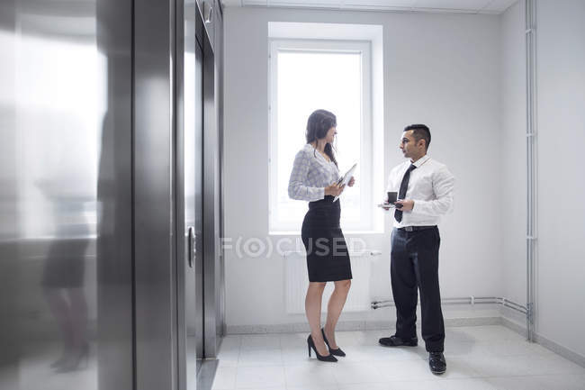 Colleghi che parlano in corridoio — Foto stock