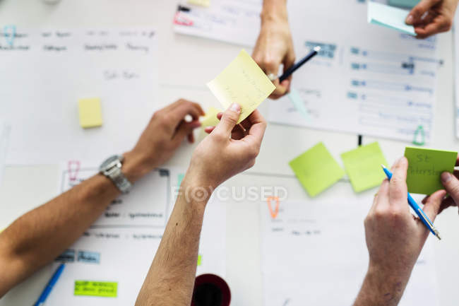 Top view of colleagues using adhesive notes during business meeting — Stock Photo