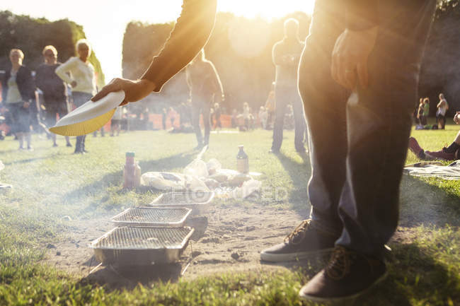 Malmo, Sweden - May 26, 2016: Man inflates grills on ground at picnic on lawn — Stock Photo