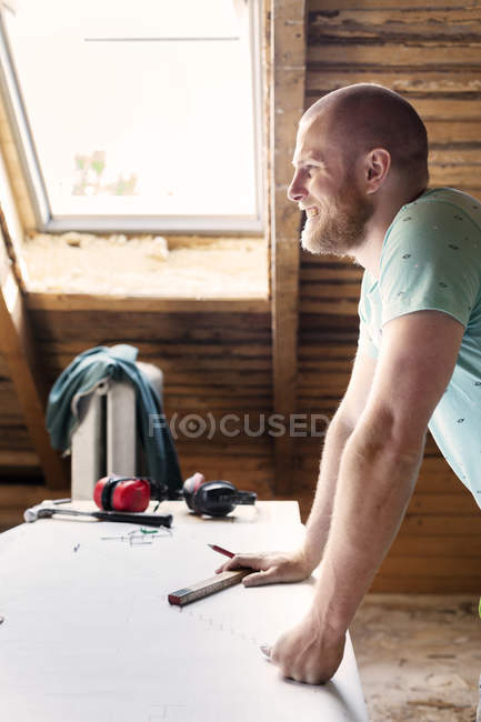 Mann lächelt auf altem Dachboden — Stockfoto