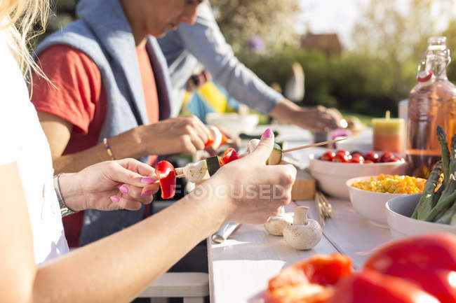 Люди готовят еду для вечеринки в саду — стоковое фото