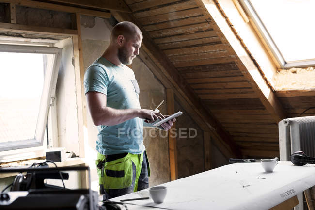 Hombre trabajando en la renovación del viejo ático - foto de stock