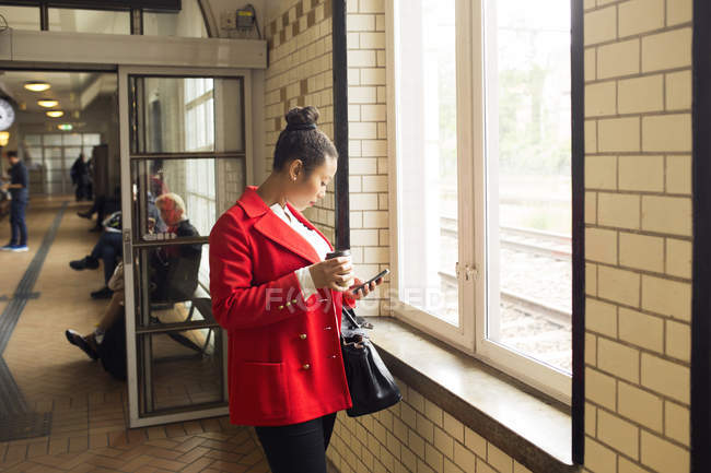 Femme debout à côté de la fenêtre — Photo de stock