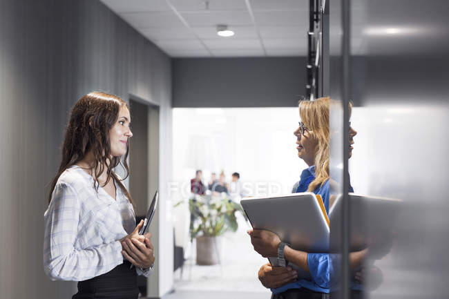 Жінки розмовляють в офісному коридорі — стокове фото