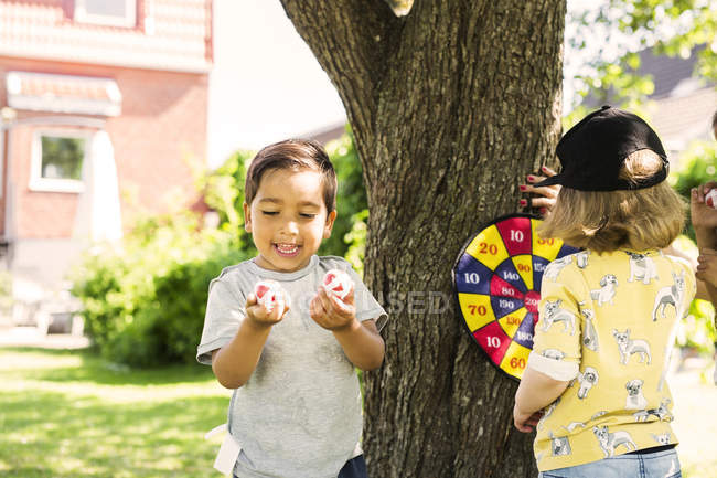 Niños jugando con dardos de mesa - foto de stock