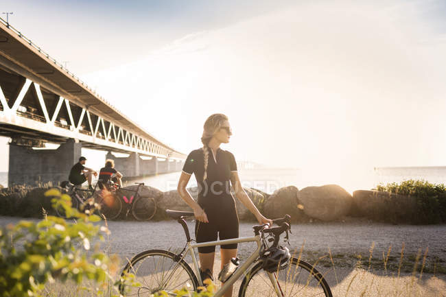 Велогонщики под мостом на береговой линии — стоковое фото