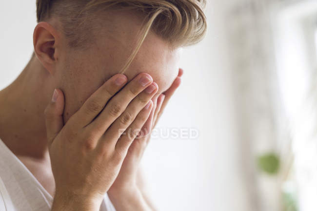 Pensive young man with head in hands — Stock Photo