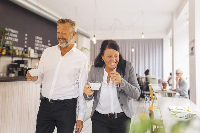 Hombre mayor y mujer madura riendo en la cafetería - foto de stock