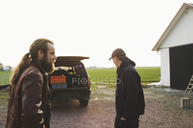 Двое мужчин стоят на машине — стоковое фото