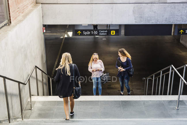 Giovani donne in piedi vicino alle scale — Foto stock