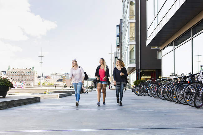 Три женщины идут вместе по улице — стоковое фото