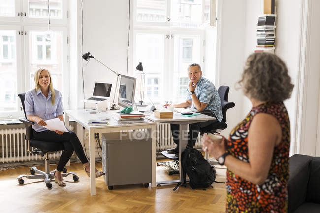 Coworkers talking in office indoors — Stock Photo