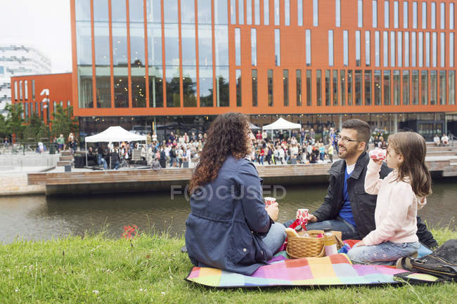 Genitori con figlia (4-5) godendo picnic con concerto in background — Foto stock
