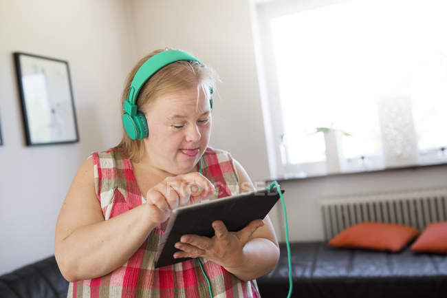 Женщина с синдромом Дауна с помощью цифрового планшета — стоковое фото