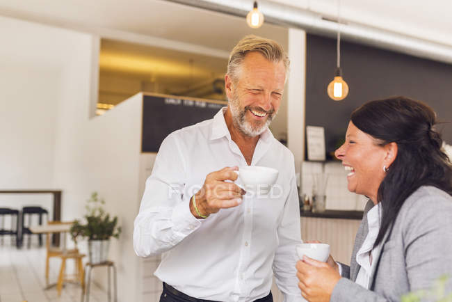 Uomo anziano e donna matura ridendo in caffè — Foto stock