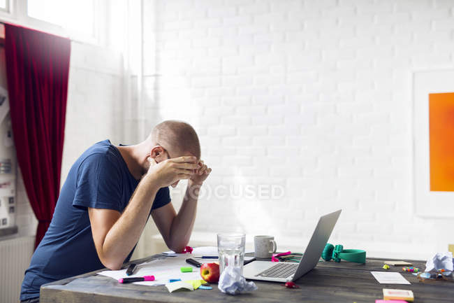 Überarbeiteter Mann liest Dokumente im Büro — Stockfoto