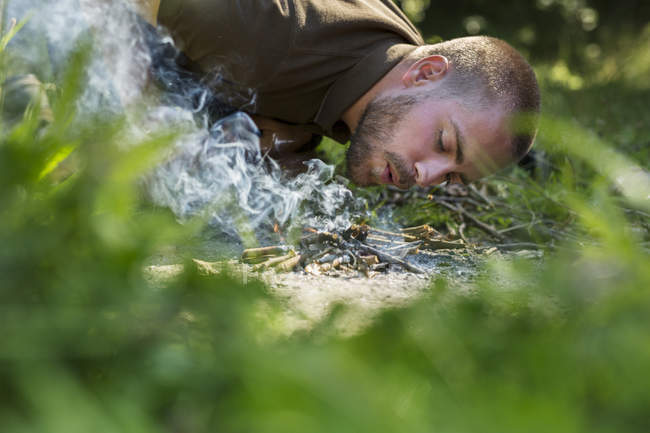 Mann entzündet Lagerfeuer im Wald — Stockfoto
