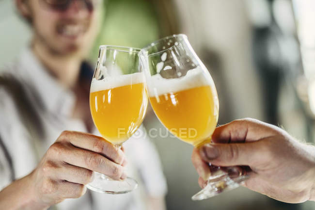 Двое мужчин звонят в пивные бокалы — стоковое фото