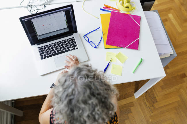 Elevated view of businesswoman using laptop in office — Stock Photo