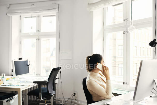 Деловая женщина разговаривает по телефону в офисе — стоковое фото