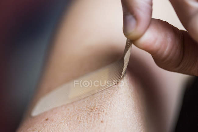 Close-up of man removing bandage — Stock Photo