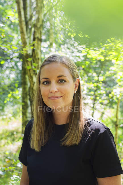 Portrait of young woman at forest — Stock Photo