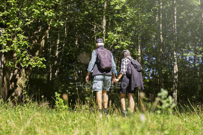 Man and woman walking in meadow — Stock Photo