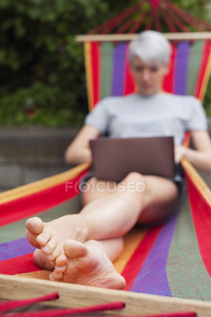 Жінка, використовуючи ноутбук на гамак денний час — стокове фото