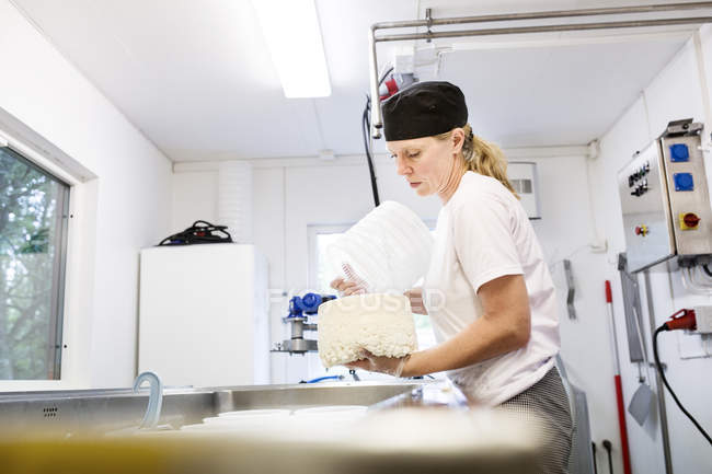 Femme préparant fromage cottage dans la cuisine commerciale — Photo de stock