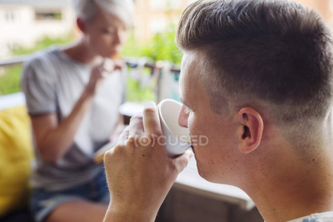Uomo che beve caffè sul balcone — Foto stock