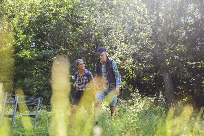 Homem e mulher caminhando no prado — Fotografia de Stock